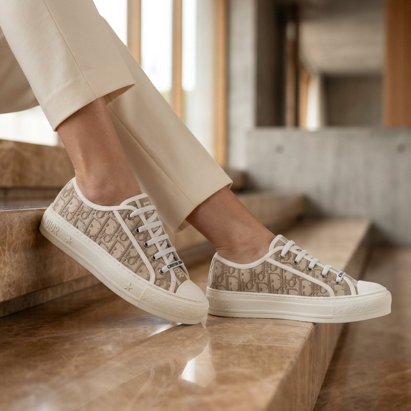 Person wearing beige sneakers with a pattern, standing on a staircase.