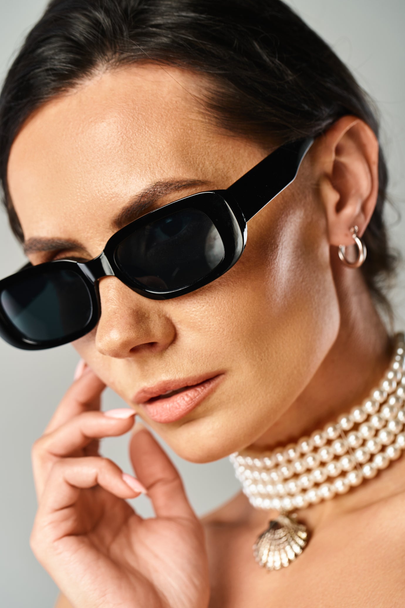 sunglasses on a women wearing a pearl necklace